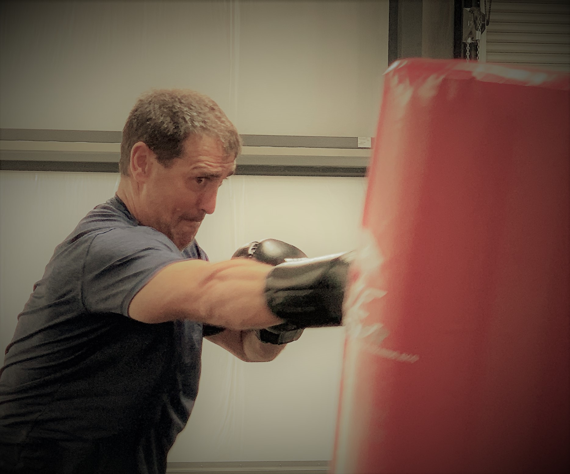 Boxer with Parkinson's disease hitting heavy bag