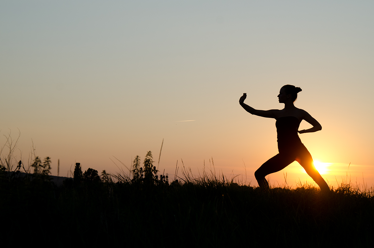 Silhouette of woman doing Tai Chi